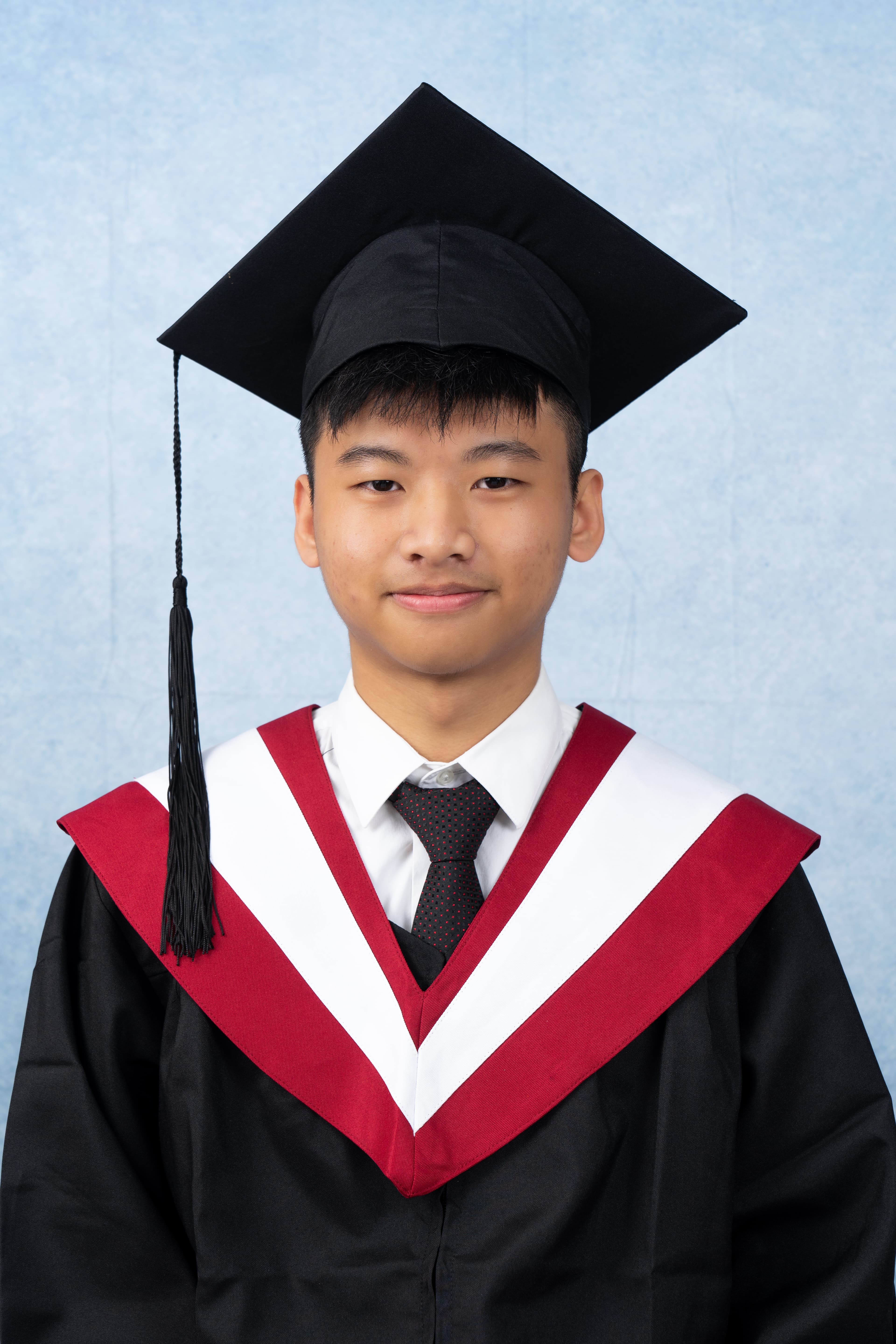Jerry Chen smiling in a lab surrounded by robotics equipment